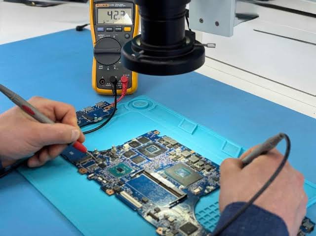 Chip-level laptop motherboard diagnostic and soldering repair setup at service center